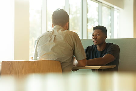 two man sitting beside the brown table inside the store thumbnail
