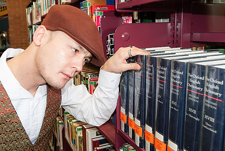 man staring on blue hardbound book thumbnail