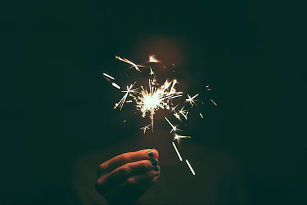 person holding sparkler lit on thumbnail