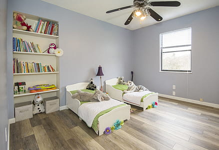 Two Single Beds Beside Books Shelf Inside Room thumbnail
