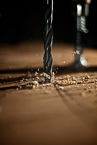 selective focus photography of black drill bit on brown wooden board thumbnail