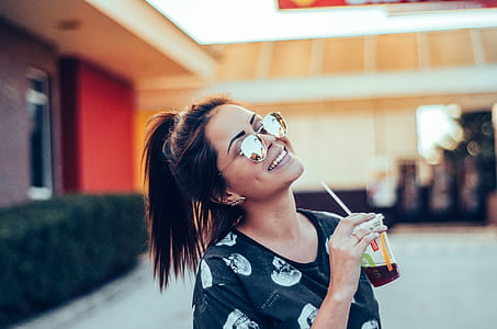 woman facing upward while holding plastic tumbler thumbnail