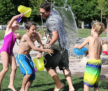 man in gray shirt playing together with three children thumbnail