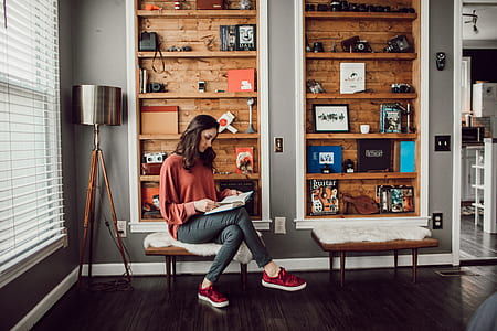 woman sitting on chair reading inside room thumbnail
