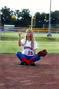 woman sitting in ballpark throwing softball thumbnail