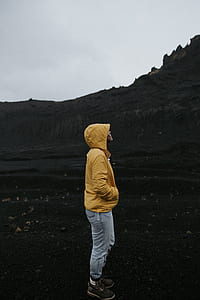 person in yellow hoodie standing on black soil; thumbnail
