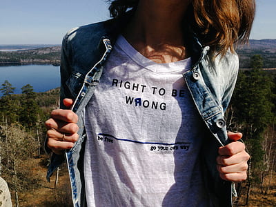 woman holding her denim jacket wearing white v-neck shirt thumbnail