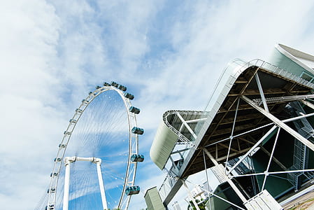 white ferris wheel near buildings under white and blue sky at daytime thumbnail
