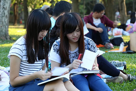 two girls sitting on grass at daytime thumbnail