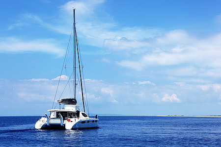 sailing boat on body of water under white clouds thumbnail