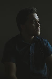 man in blue collared top staring on his left side thumbnail