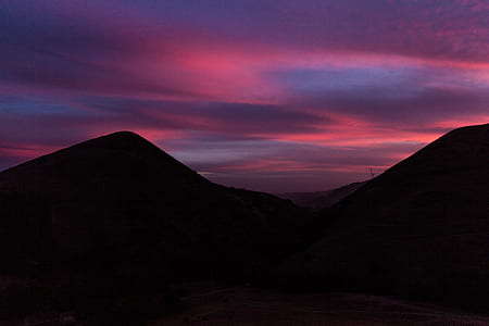 silhouette of hill under pink and gray sky thumbnail
