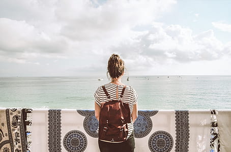 woman in black and white striped shirt standing in front of sea thumbnail