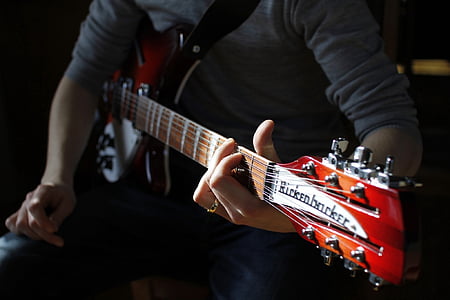 person playing brown guitar thumbnail