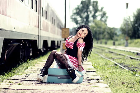 woman sitting on teal luggage thumbnail