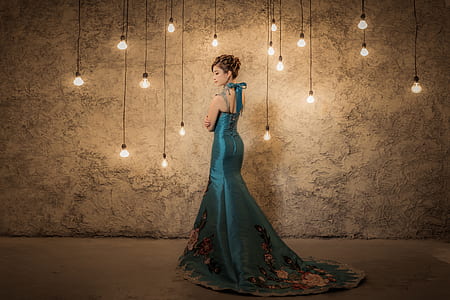 standing woman wearing green sleeveless long dress thumbnail