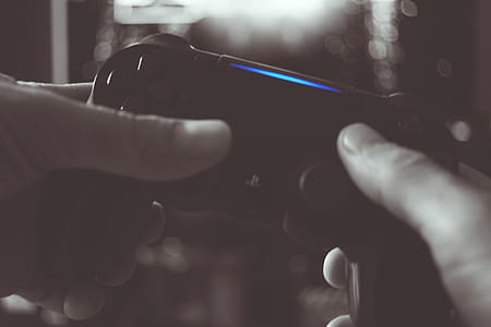 Black And White Photo Of Man Holding Sony Ps4 Wireless Controller thumbnail