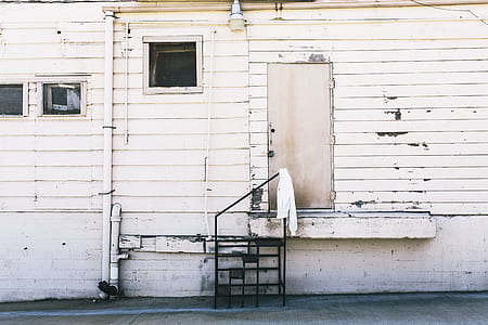 white apparel hanged on black metal ladder beside house door at daytime thumbnail