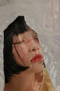 close up photo of woman closing her eyes in white floral cloth thumbnail