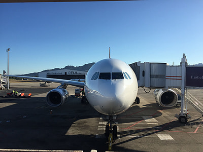white airliner at airport thumbnail