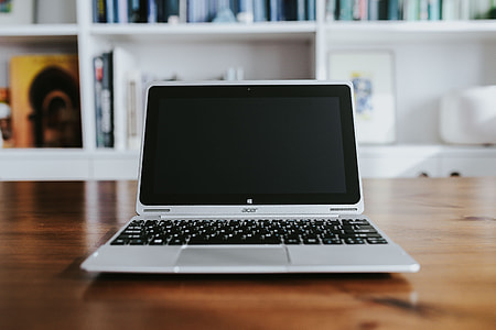 Silver laptop with various items on a table thumbnail