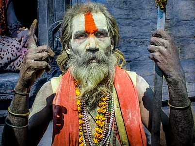 man wearing orange scarf holding rod thumbnail