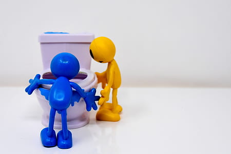 blue and yellow characters standing beside toilet bowl illustration thumbnail