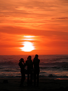 silhouette of three people on shoreline during sunset thumbnail