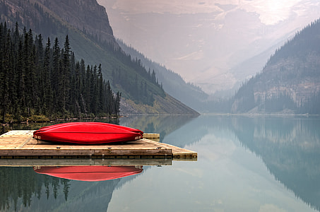 red canoe on brown wooden dock during daytime thumbnail