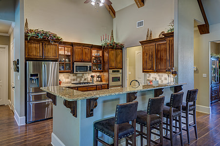 several brown wooden framed leather padded armless bar chairs in front of gray marble-top bar counter inside well lighted room thumbnail