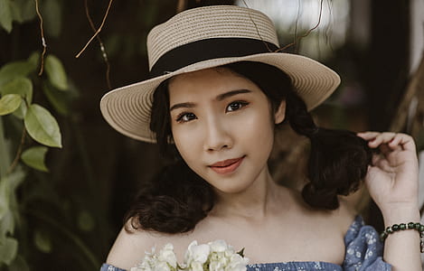 Focus Photography of Woman in Brown Sunhat Near Vine Plant thumbnail