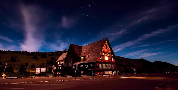 in distant photo of brown house with turned-on lights thumbnail