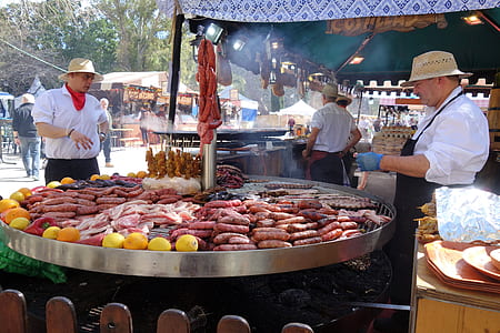 man standing in front of round industrial griller thumbnail