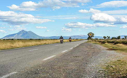 person driving motorcycle on road under blue sky thumbnail