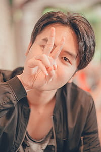 Man in Black Leather Zip-up Jacket Showing Peace Sign thumbnail