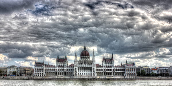 white and brown concrete building near body of water thumbnail
