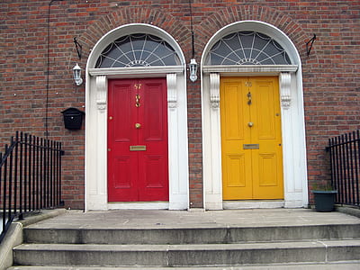 two closed red and yellow doors beside grey concrete stairs thumbnail