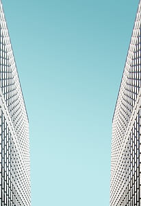 two gray-and-black building with blue sky thumbnail