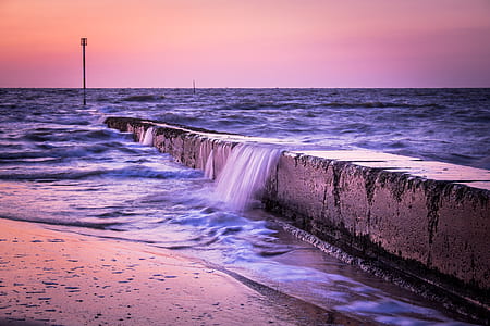 body of water hitting gray concrete barrier thumbnail