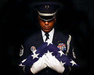 person holding folded U.S.A flag thumbnail