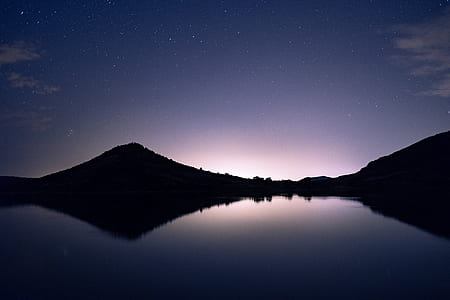 silhouette photo of mountain reflecting body of water thumbnail