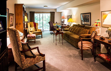 brown couch beside brown wooden armchair during daytime thumbnail