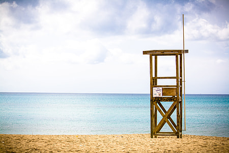 brown watch tower near body of water during daytime thumbnail
