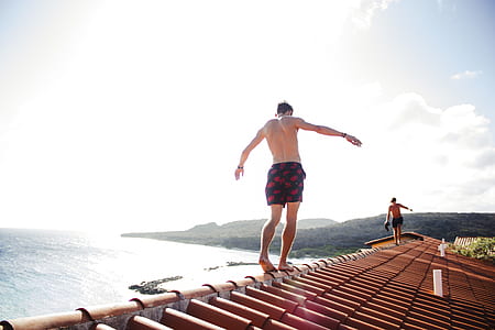 topless man walking on roof during daytime thumbnail