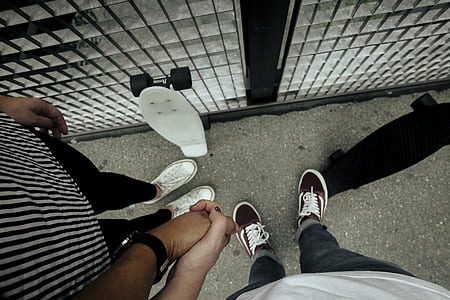 two person holding hands together with cruiser boards thumbnail