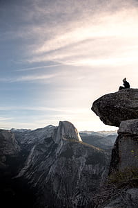 person sitting on rock mountain cliff thumbnail
