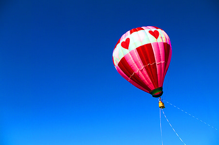 pink and gray hot air balloon under blue sky thumbnail