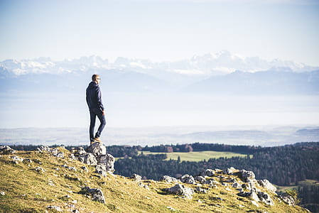 man in black jacket standing on rock thumbnail