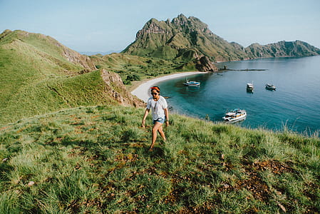 woman walking on green grass field during daytime thumbnail