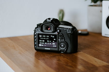 black DSLR camera on top of brown wooden table thumbnail